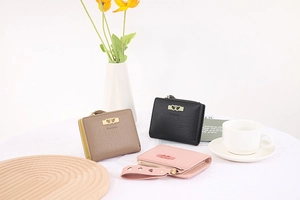 Three leather short wallets in pink, black, and brown with gold heart metal detail