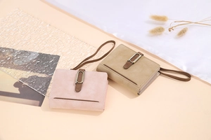 Detail of vintage matte PU leather short wallets in pink and khaki with metal buckles