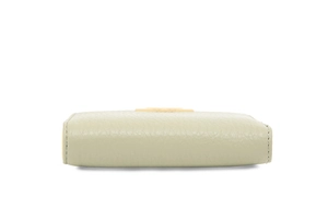 Side view of light green leather wallet showing pebbled texture and gold metal logo