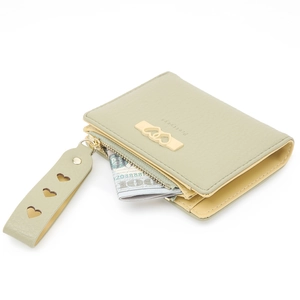 Close-up of sage green bifold wallet showing litchi texture and gold heart charm