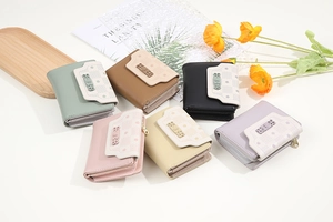 Collection of short tri-fold wallets in pastel colors with bow decoration and geometric pattern