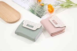 Close-up of mint green and pink floral bifold wallets with decorative petal clasps
