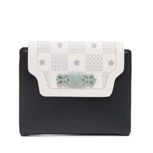 Detail of bicolored short wallet featuring floral print and flower-shaped metal clasp