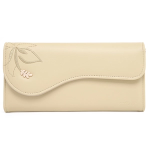 Close-up of yellow leather wallet featuring wavy flap, leaf embroidery and metal pendant