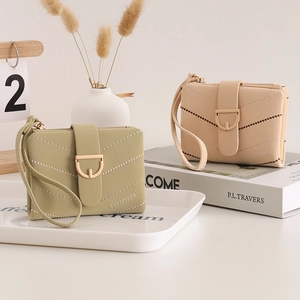 Detail of quilted leather wallets with bead accents and D-ring buckle in soft lifestyle setting
