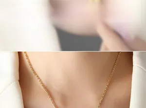 Close-up of golden geometric pendant necklace with OT toggle clasp on a model