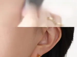 Mannequin portant des boucles d'oreilles en C dorées avec détails en zircon blanc et vert