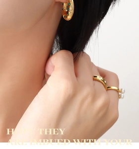 Détail des boucles d'oreilles C dorées 18K avec zircon vert et bagues en perles