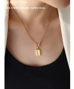 Detail of 18K gold-plated OT clasp necklace with rectangular pendant and zircon stone