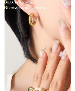 Gros plan détaillé des boucles d'oreilles C et de la bague plaqué or 18K avec zircons