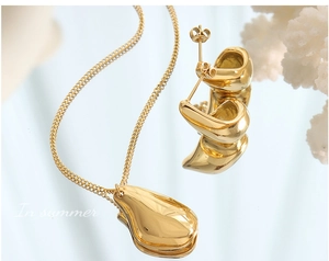 Détail du collier et des boucles d'oreilles dorés polis en forme de goutte d'eau