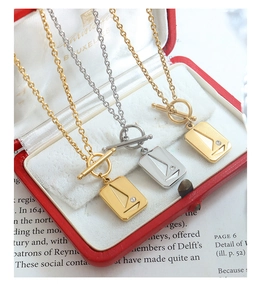 Detail of square zircon necklaces with vintage OT buckles on a classic red jewelry box