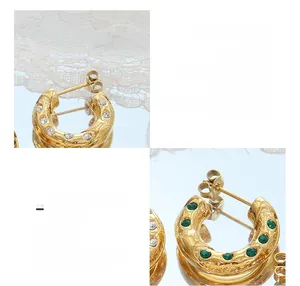 Détail de boucles d'oreilles C en titane plaqué or 18K avec zircons blancs et verts
