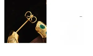 Gros plan détaillé des boucles d'oreilles en C plaqué or 18K avec zircons verts