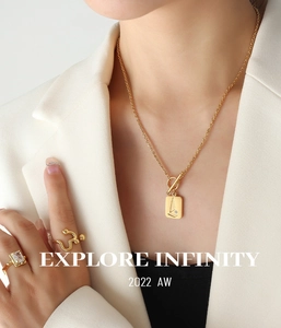 Detail of 18K gold-plated rectangle pendant necklace and square zircon ring on a model
