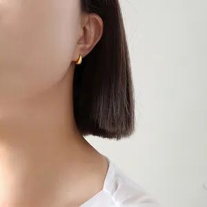 Minimalist gold teardrop earrings for women shown on model in a high-quality fashion shot