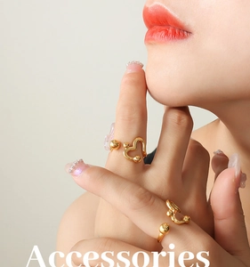 Detail of adjustable hollow heart ring with golden finish and polished ball accent