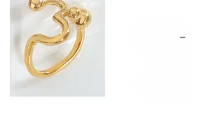 Detailed view of golden wavy textured ring with minimalist irregular metal bead design