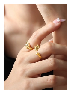 Close-up of a minimalist golden fox-shaped open ring on a female model's finger