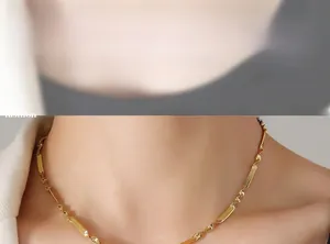 Close-up of minimalist gold titanium necklace with twist chain and polished plaques