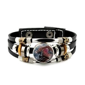 Detail of multi-layer leather bracelet with red dragon glass gem and metallic snaps