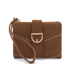 Detailed view of brown quilted short wallet with gold metal clasp and wrist strap