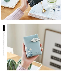 Gros plan du portefeuille floral bleu clair avec boucle feuille et motif marguerite