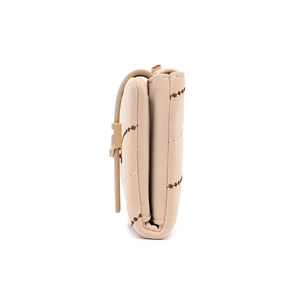 Side view detail of beige quilted wallet with star embroidery and secure folding structure