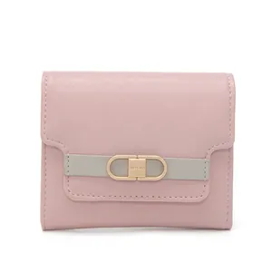 Detail of a pink and gray trifold wallet with gold buckle and engraved brand logo