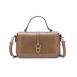 Détail d'un sac à bandoulière marron avec coutures contrastées et boucle en métal