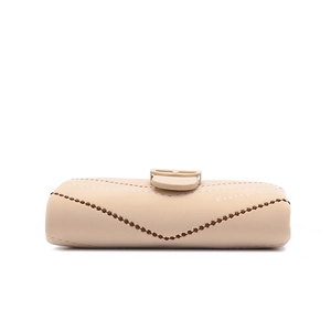 Detail of light khaki leather glasses case with decorative serrated edges and snap closure