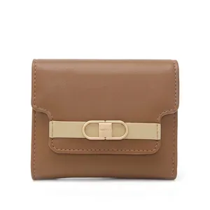 Close-up of brown leather trifold wallet with gold clasp and beige trim detail