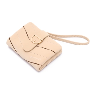 Detailed macro view of beige retro quilted wallet with gold clasp and hand strap