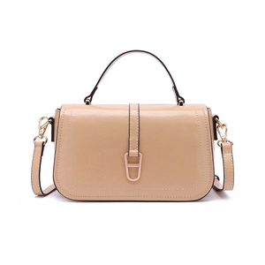 Détail du sac à bandoulière beige en similicuir brillant avec boucle dorée