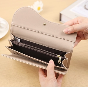Detail view of beige saddle flap wallet interior showing multiple card slots and zip pocket