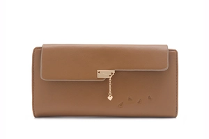 Detail of long brown wallet featuring golden square plate and hanging heart charm detail