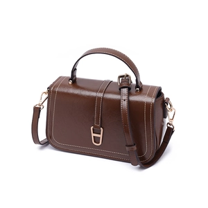 Détail du sac bandoulière vintage marron foncé avec surpiqûres et boucle en métal fer à cheval
