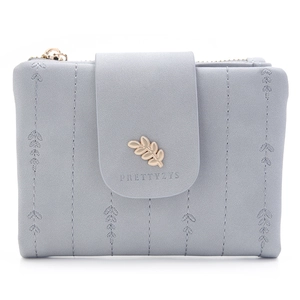 Detail view of leaf-shaped embroidery and gold leaf metal clasp on gray blue wallet