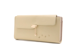 Detail view of cream long wallet with golden heart pendant and embossed heart patterns