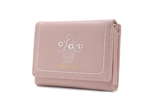 Detail of a dusty pink trifold wallet featuring floral embroidery and stitched edges