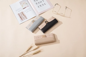 Detailed close-up of three long PU leather wallets with floral print and gold buckles