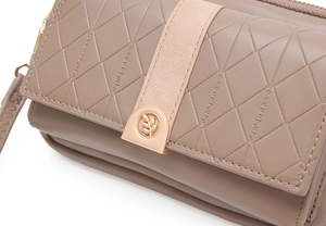 Detail einer gesteppten terracotta Tasche mit roségoldenem Metall-Blattverschluss