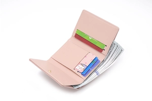 Detail view of pink tri-fold wallet with four card slots and spacious cash compartment