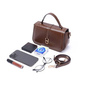 Sac bandoulière en cuir PU marron avec poignée et boucle en D dorée sur fond blanc