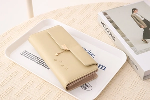 Macro detail of beige PU leather long wallet with heart pendant and multi-card slots