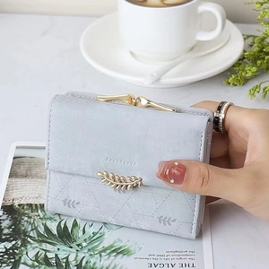 Detail of grey-blue quilted leather wallet with gold leaf clasp and floral prints