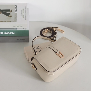 Détail d'un sac en cuir crème avec boucle en métal doré et bandoulière réglable