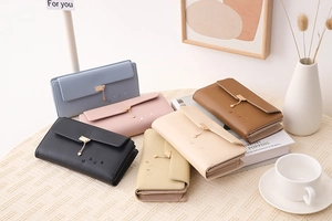 Close-up of long trifold wallets featuring heart pendants and elegant embossed patterns