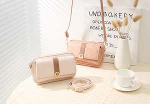Detail von gesteppten Leder-Mini-Umhängetaschen mit Goldbeschlägen im Sonnenlicht