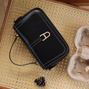 Détail de sac à main vintage en cuir PU noir avec coutures blanches et fermoir doré